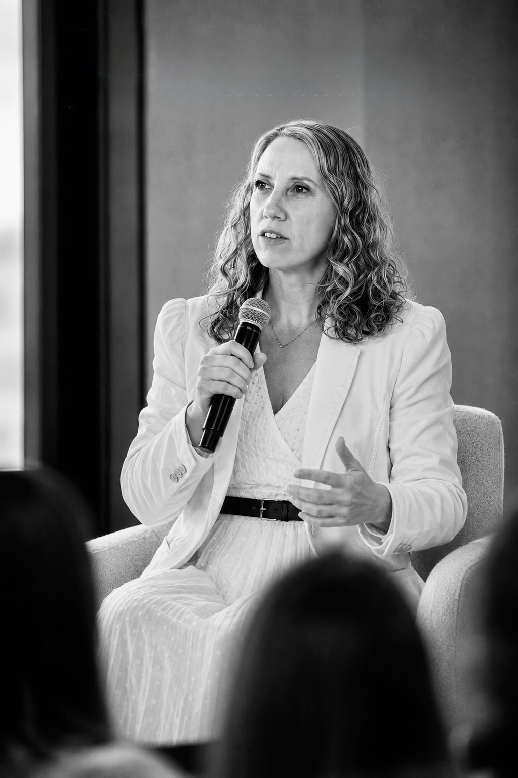 Jasmine Rohland seated and speaking into a microphone in front of an audience